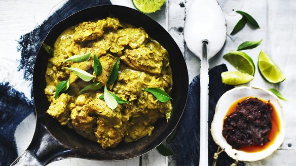 Lime wedges, fresh curry leaves and chilli sauce add colour to this chicken curry image.