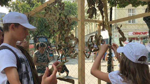Children in Lviv, western Ukraine, tying cloth into camouflage netting for soldiers fighting in the east.