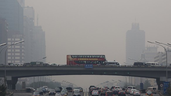 Pollution haze shrouds heavy traffic on the roads of Beijing on Tuesday. The Chinese capital city was hit by thick pollution although municipal transport authorities set up three car-free zones for World Car Free Day.