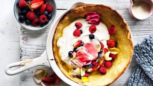 Dutch baby pancake dressed up with berries and rose petals. 
