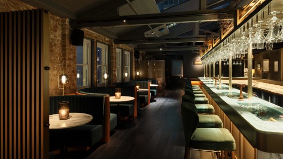 The new bar boasts dark timber, brass detailing, emerald banquettes and antique mirrors at Spice Trader.