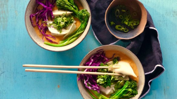 Dumplings swimming in red curry sweet potato soup.