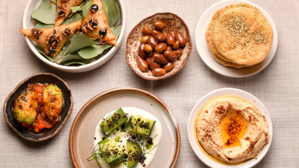 The opening flurry of snacks starring Turkish breads, hummus, and arak cucumbers.