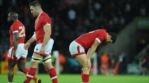 Canada players stand dejected on the pitch after Romania beat them 15-17 in their Pool D match.