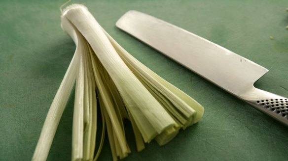 Remove the leek's green part, and slice the length of the whites, leaving the root intact.