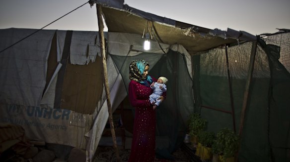 Syrian refugee Huda Alsayil, 20, holds her newborn son Mezwid at an informal settlement on the outskirts of Mafraq, Jordan.