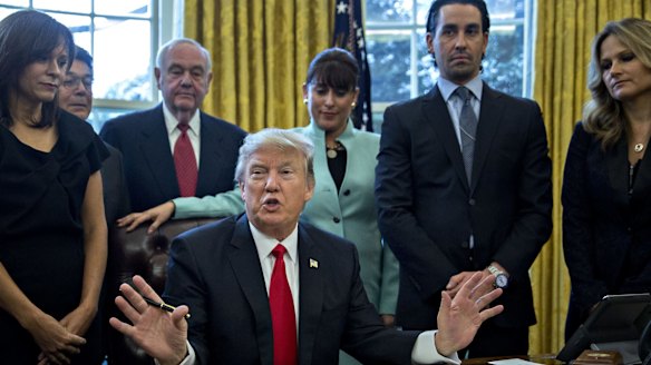 Stand up: US President Donald Trump speaks before signing another executive order cutting federal regulations while surrounded by small business leaders in the Oval Office.