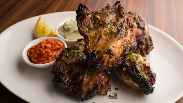 The signature rotisserie chicken, with blackened skin and garlic and chilli sauces.