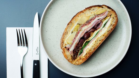 The muffuletta, a pressed baguette of olive, mortadella, salami, ham, provolone, peppers and artichokes.