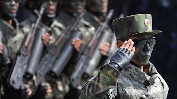 'Our ultimate dignity': North Korean commandoes march across Kim Il-sung Square during a military parade on Saturday.
