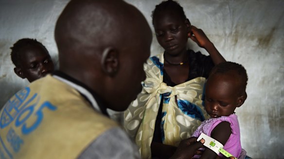 Nyanget Thac, 22, takes her daughter Nyalen Gatmai, 2, for a health check at a CARE nutrition clinic.