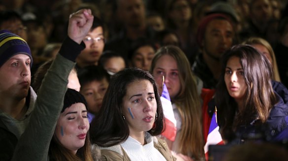 Women sing the French national anthem at a vigil in Sydney following the attack in Nice.