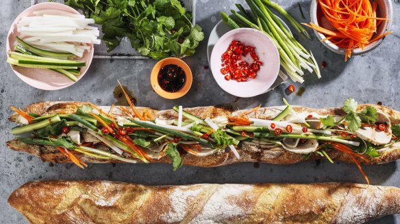 Adam Liaw's mega banh mi is drizzled with seasoning before serving.