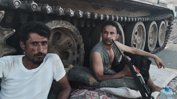 Militia loyal to Yemen's President Abed Rabbo Mansour Hadi rest near their tank on Saturday. 