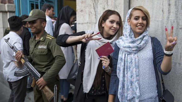 Voters show their ink-stained fingers outside a polling station for the presidential election in Tehran.