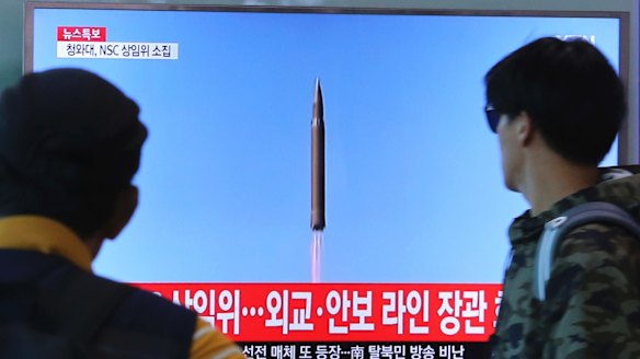 South Koreans watch a TV screen showing a file footage of North Korea's missile launch, at the Seoul Railway Station on Tuesday