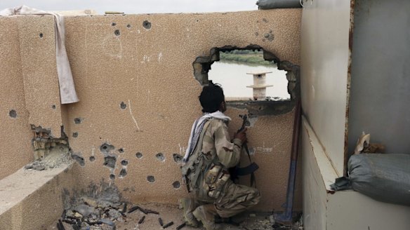 An Iraqi soldier guards a checkpoint in Tikrit.
