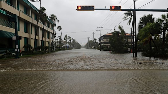 Water pours through a street in the business district of Naples, Florida, as Hurricane Irma passes through on Sunday.