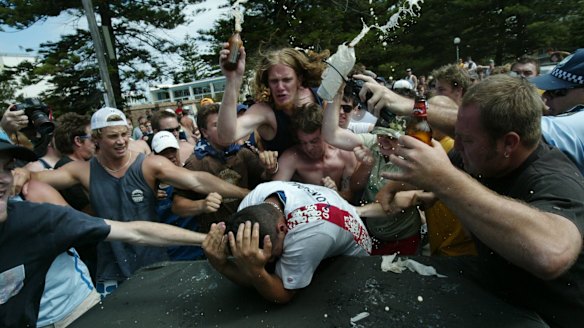 Geoffrey Atkinson, wearing a green shirt and camouflage cap, joins the mob of men attacking Safi Merhi during the Cronulla riots.