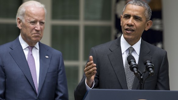 Major victory for his legacy ... President Barack Obama (right), accompanied by Vice-President Joe Biden, talks about the US Supreme Court's decision to protect the Affordable Care Act. 