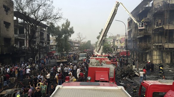 Iraqi security forces look for victims as civilians gather at the explosion site.