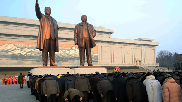 Crowds bow to the statues of North Korea's late leader Kim Jong-il, right,  and his father, North Korea's founder Kim Il-sung, which tower over the capital Pyongyang on a hill.