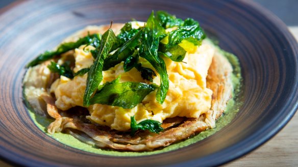 Cumin-scrambled eggs rest on flaky hand-made roti and come topped with a crown of fried curry leaves.