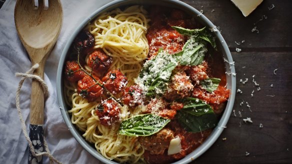 Spaghettini and meatballs scattered with fontina cheese.