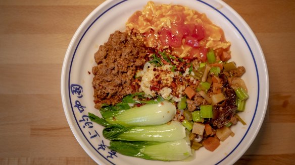 The dao xiao special biang noodle dish with pork mince, scrambled egg, potato, carrot and celery stir-fry and Asian greens.