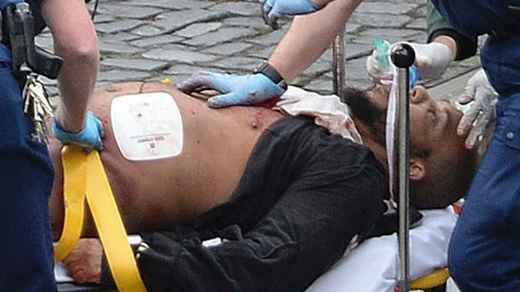 Khalid Masood is treated by emergency services outside parliament. 