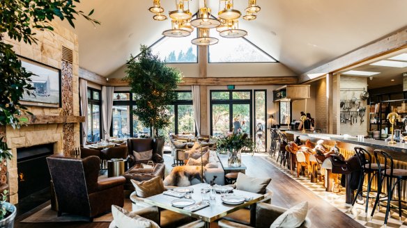 The dining room includes saddle stools and a sandstone fireplace.