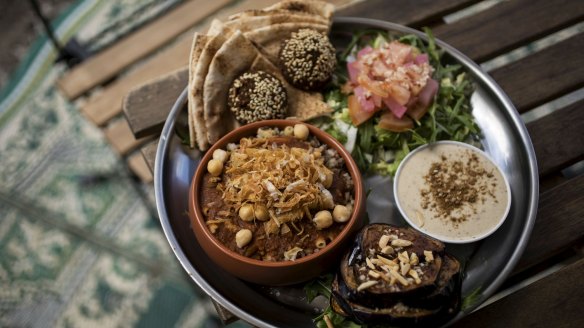 The mixed platter comes with fried eggplant, pickles, tahini dip and a stack of flatbread.