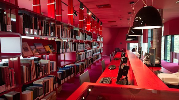 The heritage floor is decorated in bright red, with technology such as PCs, scanners and microfilm readers sitting alongside books and maps.