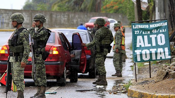 Soldiers inspect a vehicle at a checkpoint in Acapulco, Mexico on Sunday after news of El Chapo's escape. 