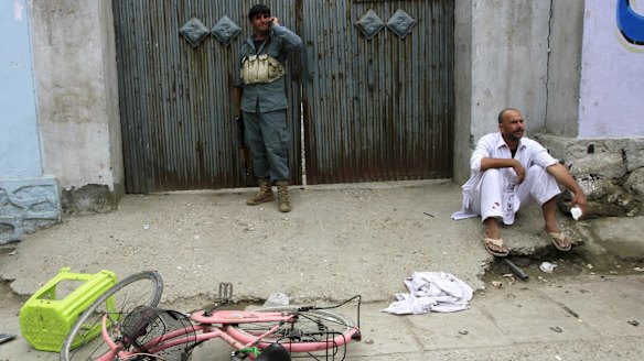 An injured man sits at the site of the explosion in Jalalabad.