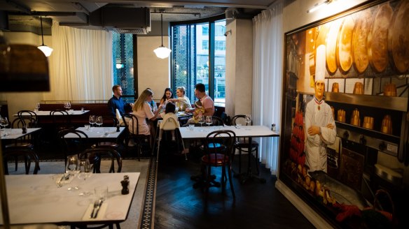 A portrait of legendary French chef Paul Bocuse watches over the room.