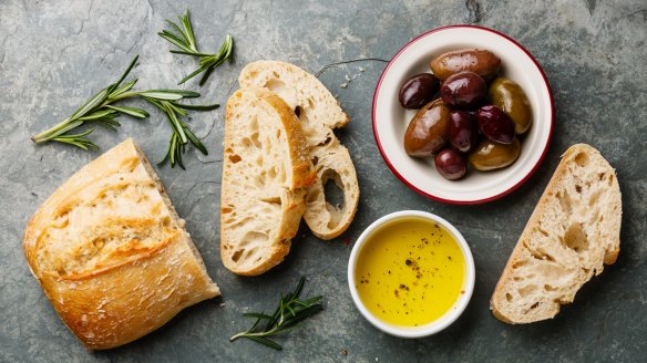 Fresh ciabatta with olive oil and olives.