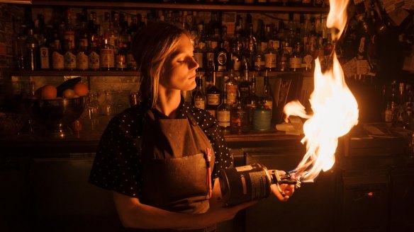 Bar manager Mary White toasts cocktail garnishes with a big butane flame.