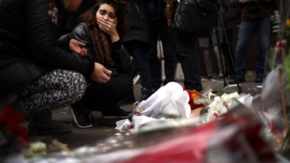 A woman places flowers near the scene of the Bataclan Theatre terrorist attack.