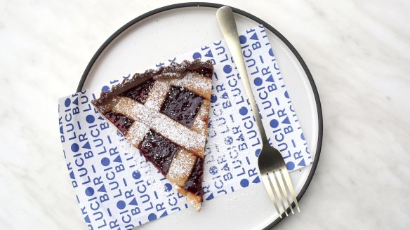 A slice of strawberry crostata – ruby red strawberry tart latticed with pastry.