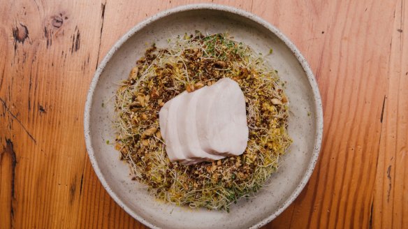 Poached chicken salad with a wreath of alfalfa sprouts, quinoa and nuts.