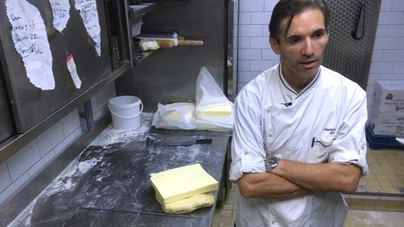 French baker Stephane Louvard stands by slices of butter in a bakery in Paris.