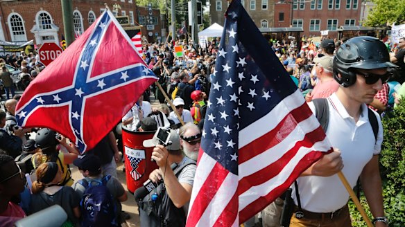 White nationalist demonstrators walk into Lee park surrounded by counter demonstrators in Charlottesville on Saturday.
