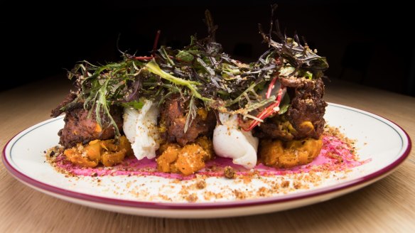 Corn fritters with poached eggs and greens.