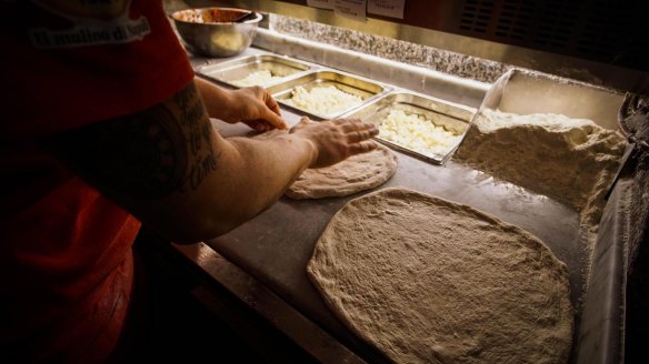 A Neapolitan 'pizzaiuolo' (pizza maker) prepares a pizza, in Naples, Italy.