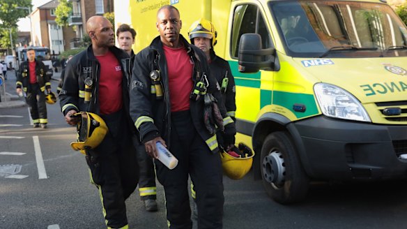 A fire crew near the 24-storey residential Grenfell Tower block. Crews searched the gutted building looking for victims.