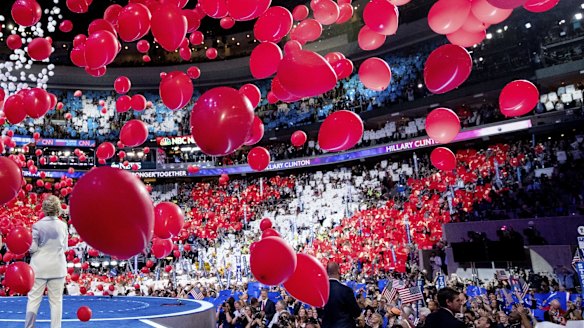 Balloons fall as Hillary Clinton stands on stage during the fourth day of the Democratic National Convention.