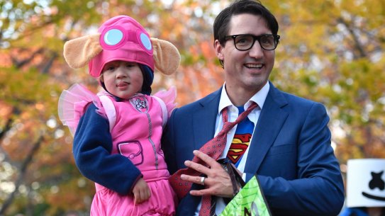 Justin Trudeau takes his youngest son Hadrien, dressed as Paw Patrol character Skye, trick-or-treating.
