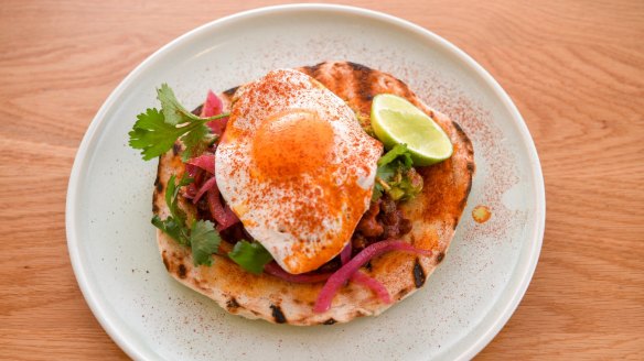 Breakfast taco with baked beans and fried egg.