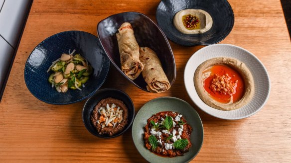 Clockwise from left: House-made hummus, spicy mizrahi zucchini, chopped liver, Lebanese cucumber and lima beans and baba ghanoush.